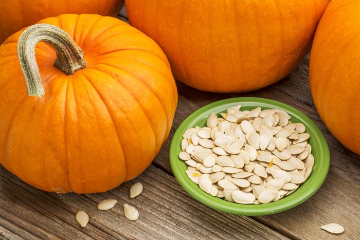 A,Bowl,Of,Fresh,Pumpkin,Seeds,On,Weathered,Wood